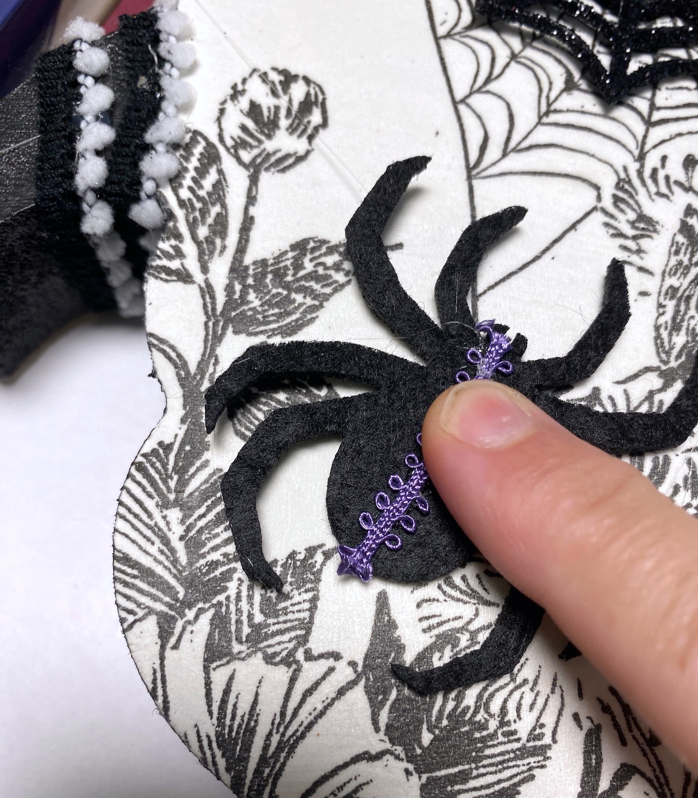 Hot gluing trim to a felt spider