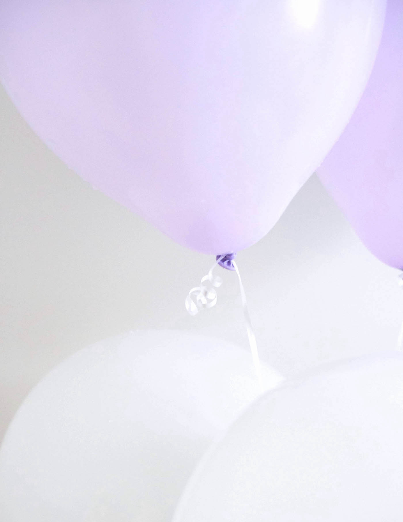 Inflated white and lavender balloons