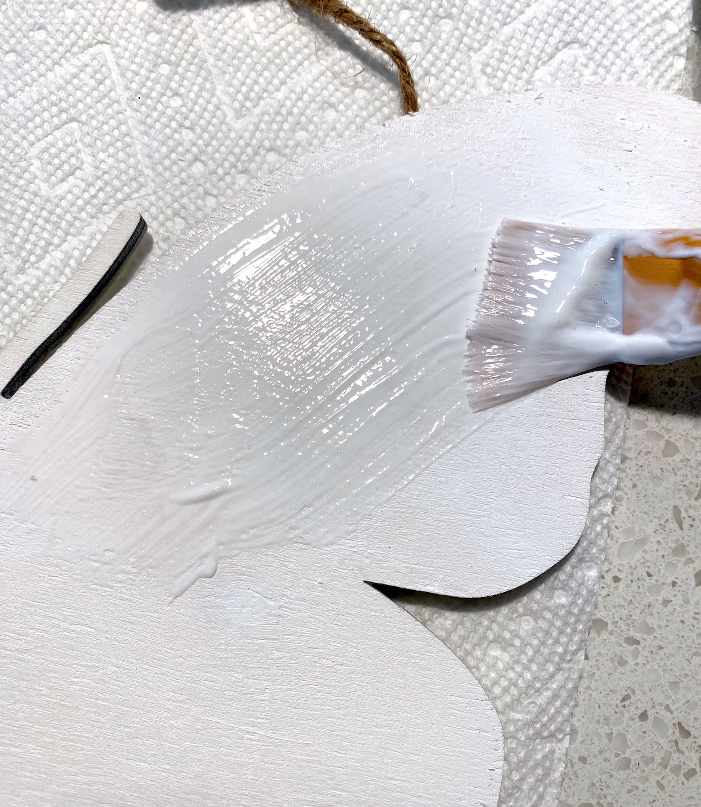 Applying a medium layer of Mod Podge to the wood butterfly