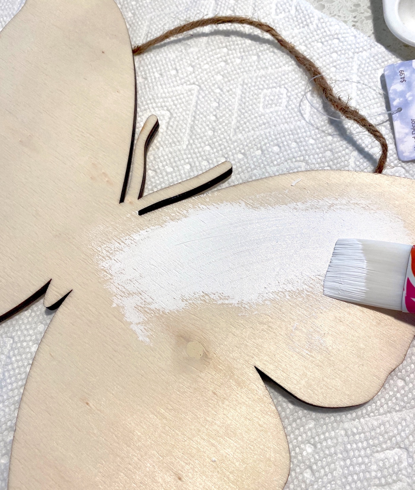 Painting the wood butterfly with white paint