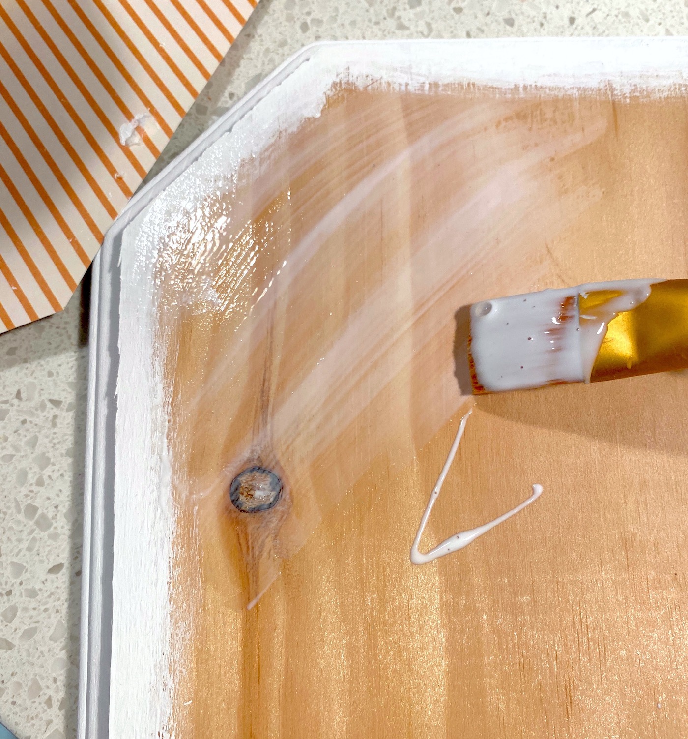 Applying Mod Podge to the top of the wood plaque