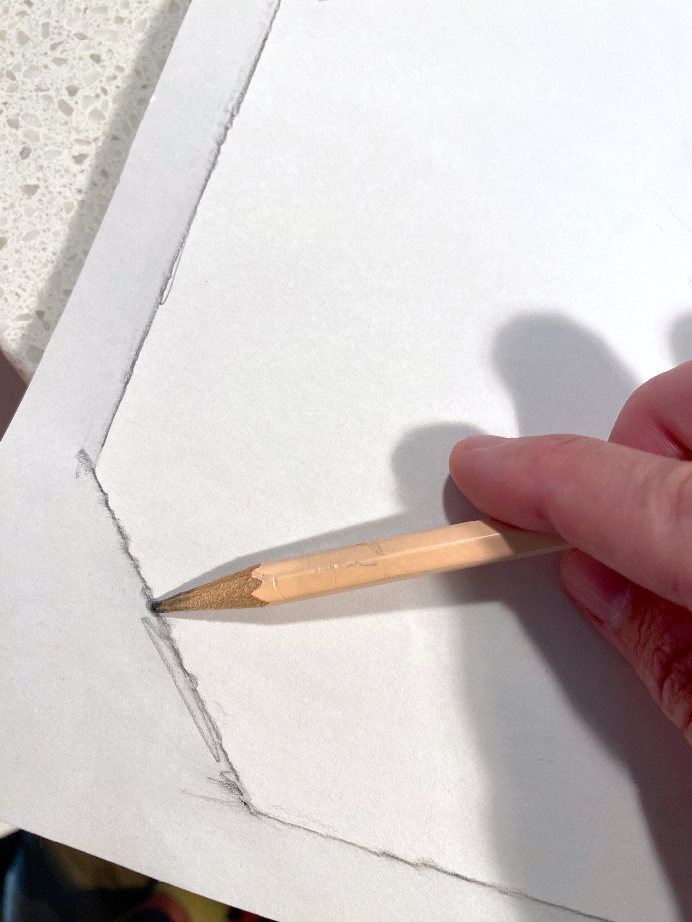 Rubbing a pencil on the edge of the plaque and paper to make a pattern