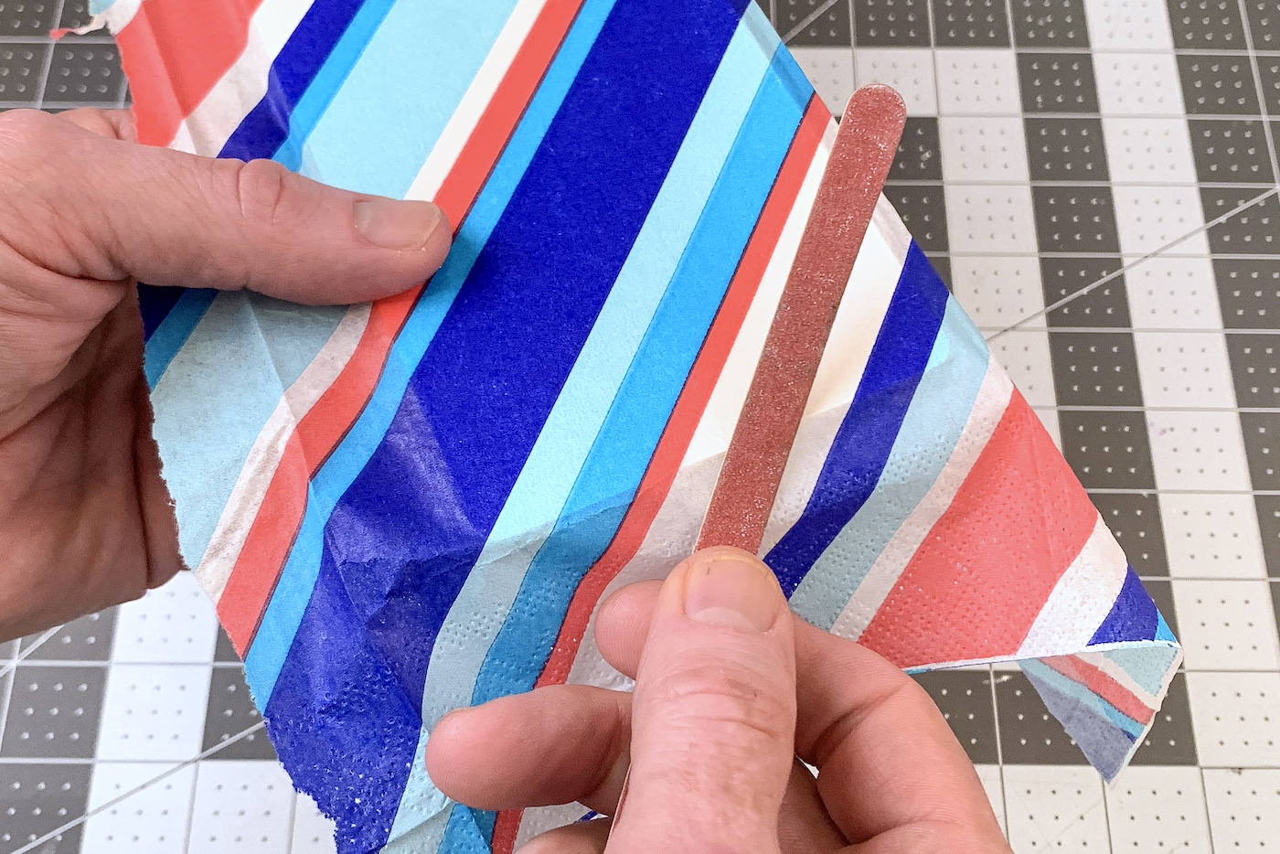 Sanding the edge of the wood door hanger with an emery board