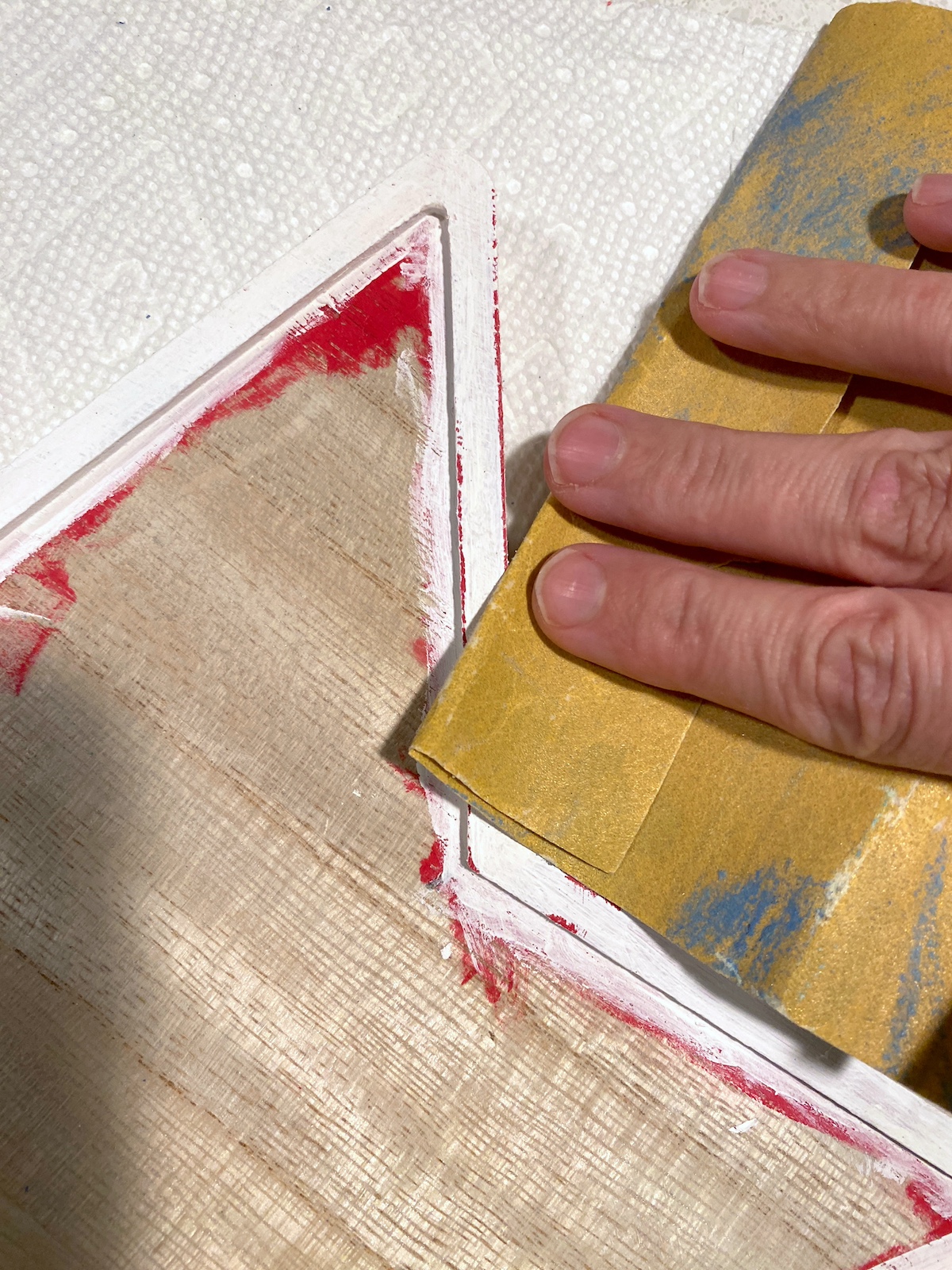 Sanding off the white paint on the star with sandpaper