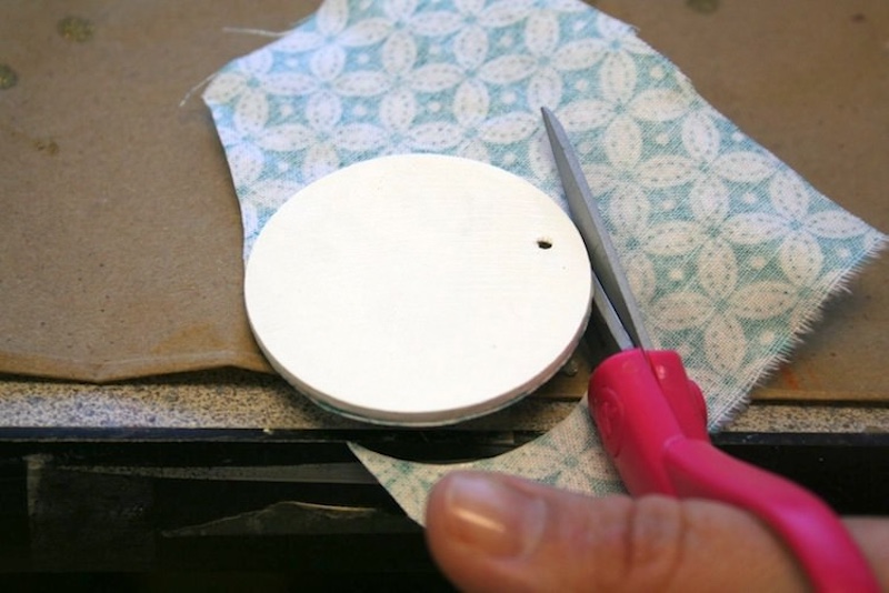 Trimming around the fabric on the wood pendant