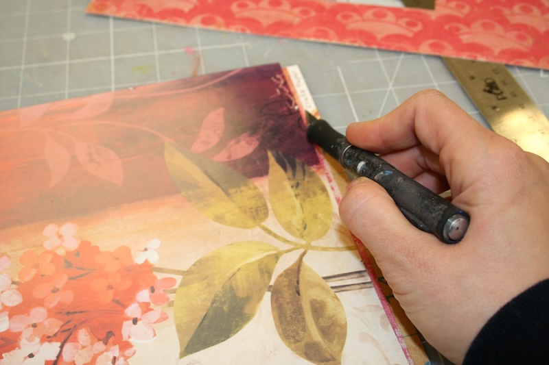 Trimming around the edges of the cardboard with a craft knife