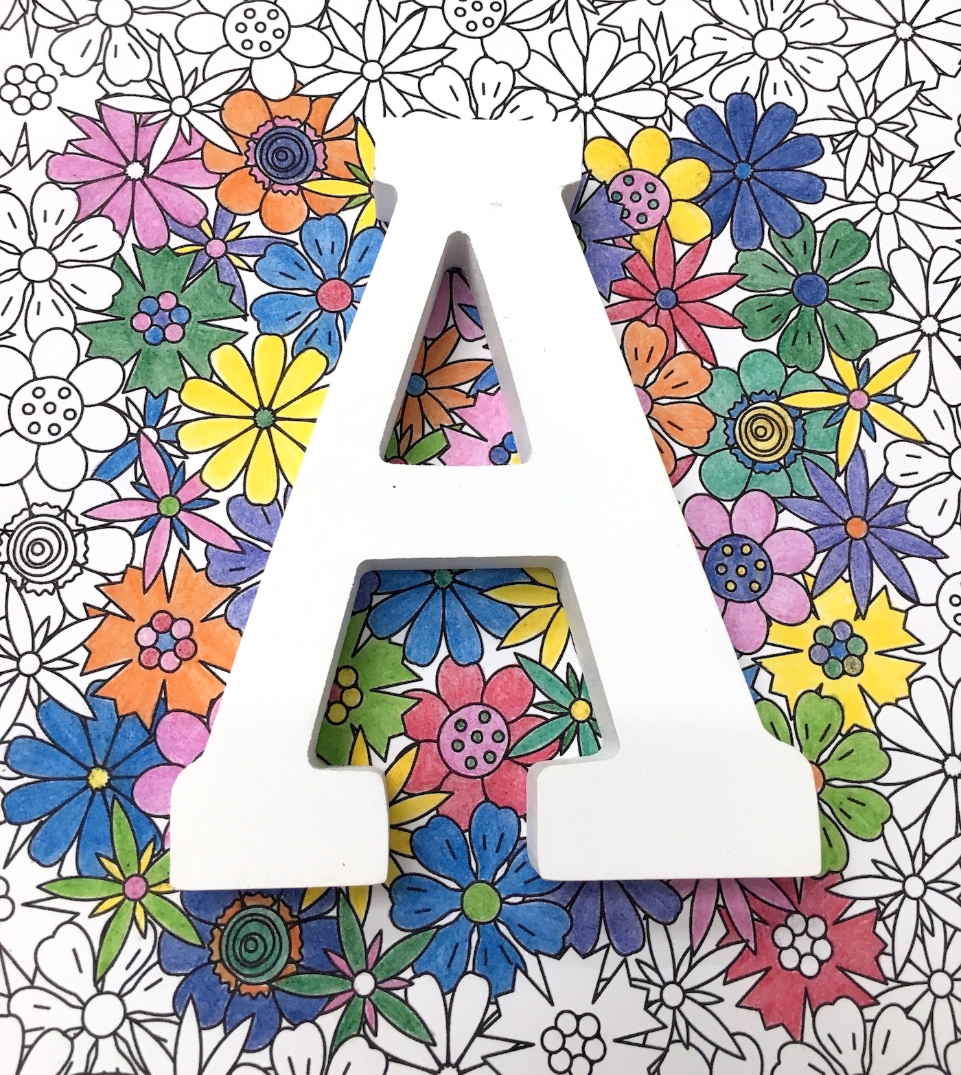 White wood letter A placed over the top of the coloring page