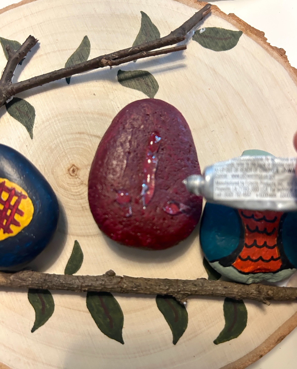 gluing the owl stones to the wood plaque